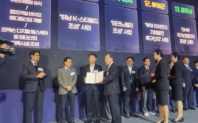 대한민국 100대 지역투자유망사업 선정 행사에서 경주시 관계자가 '경주 SMR국가산업단지 조성사업 선정 증서를 전달받고 있다