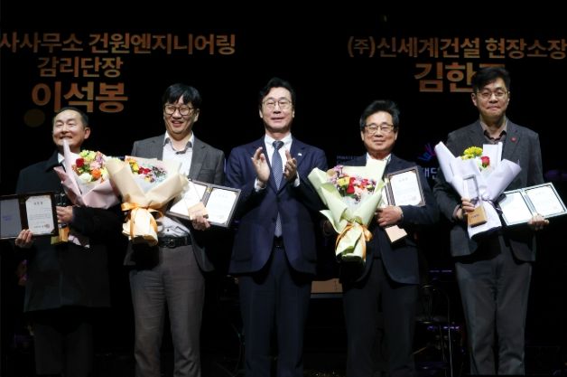 정명근 화성특례시장이 화성예술의 전당 개관기념 제야 콘서트에서 유공자들에게 특별 공로패 및 감사패를 전라하고 기념촬영을 하고 있다.