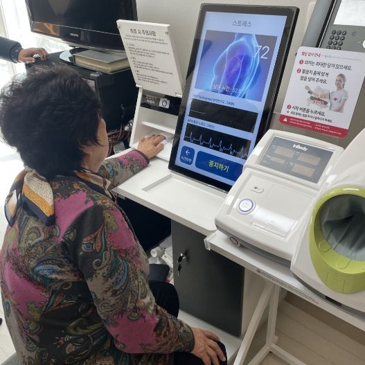 경로당에 설치된 ICT 장비를 활용하여 건강지표를 측정하는 모습